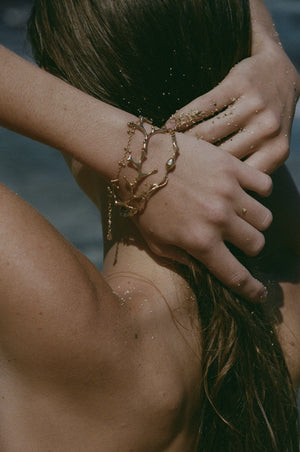 gold seaweed bracelets on wrist