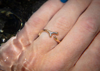 gold seaweed ring with diamond on hand in water