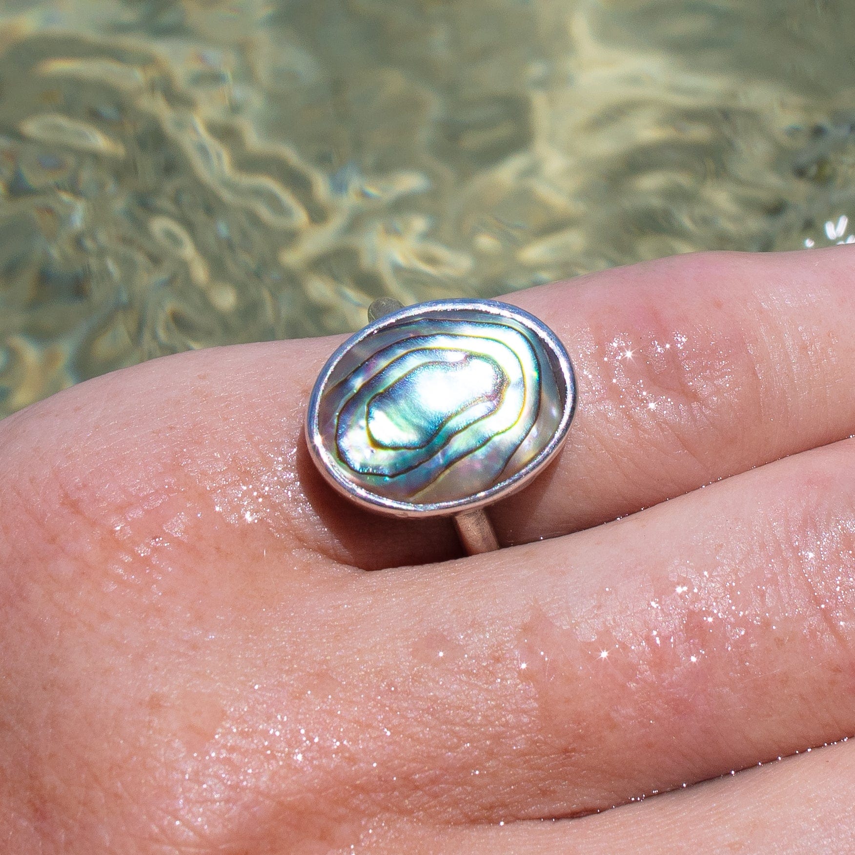 sterling silver oval abalone shell ring on wet hand