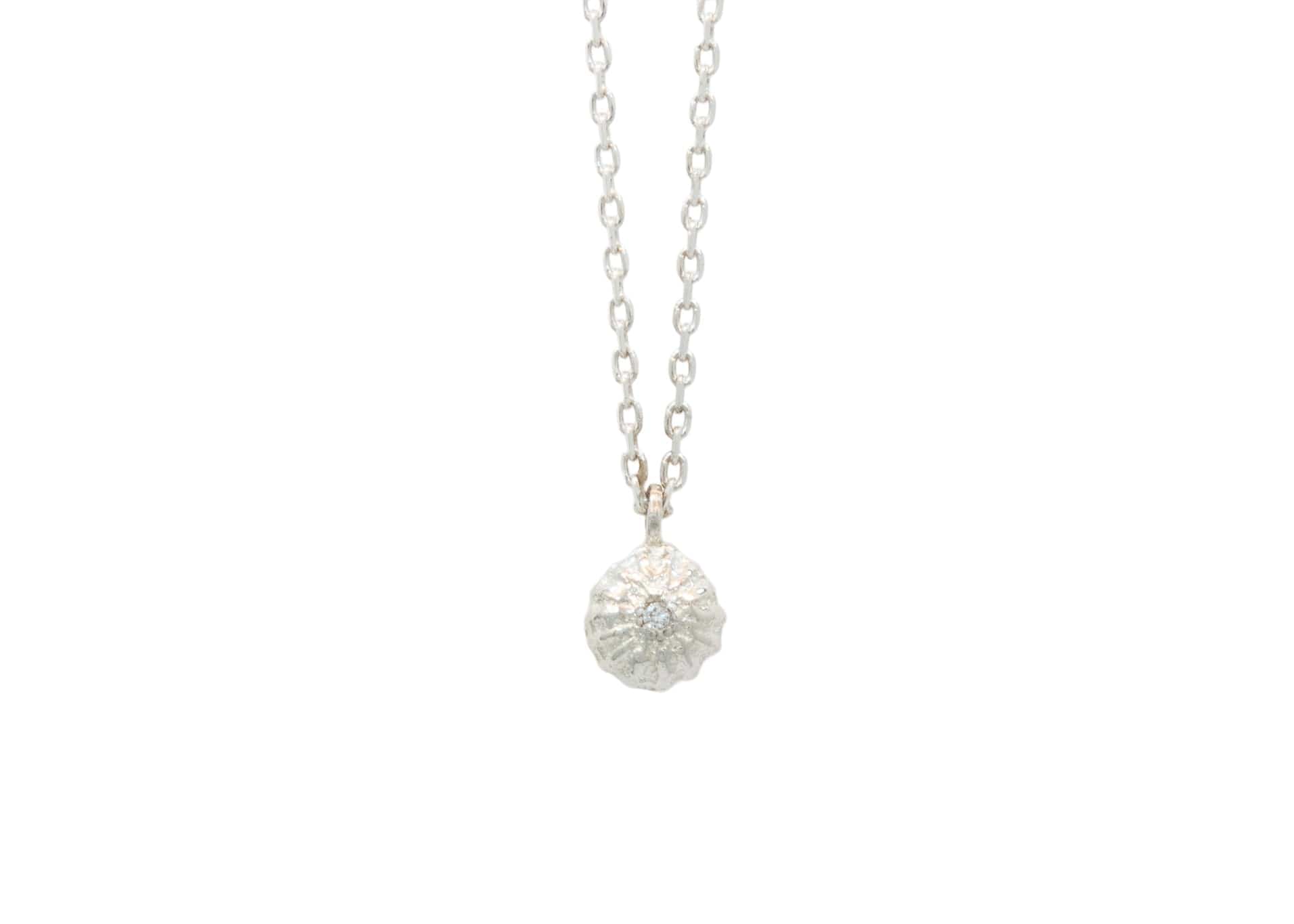 sterling silver necklace with tiny seed pendant with diamond in center
