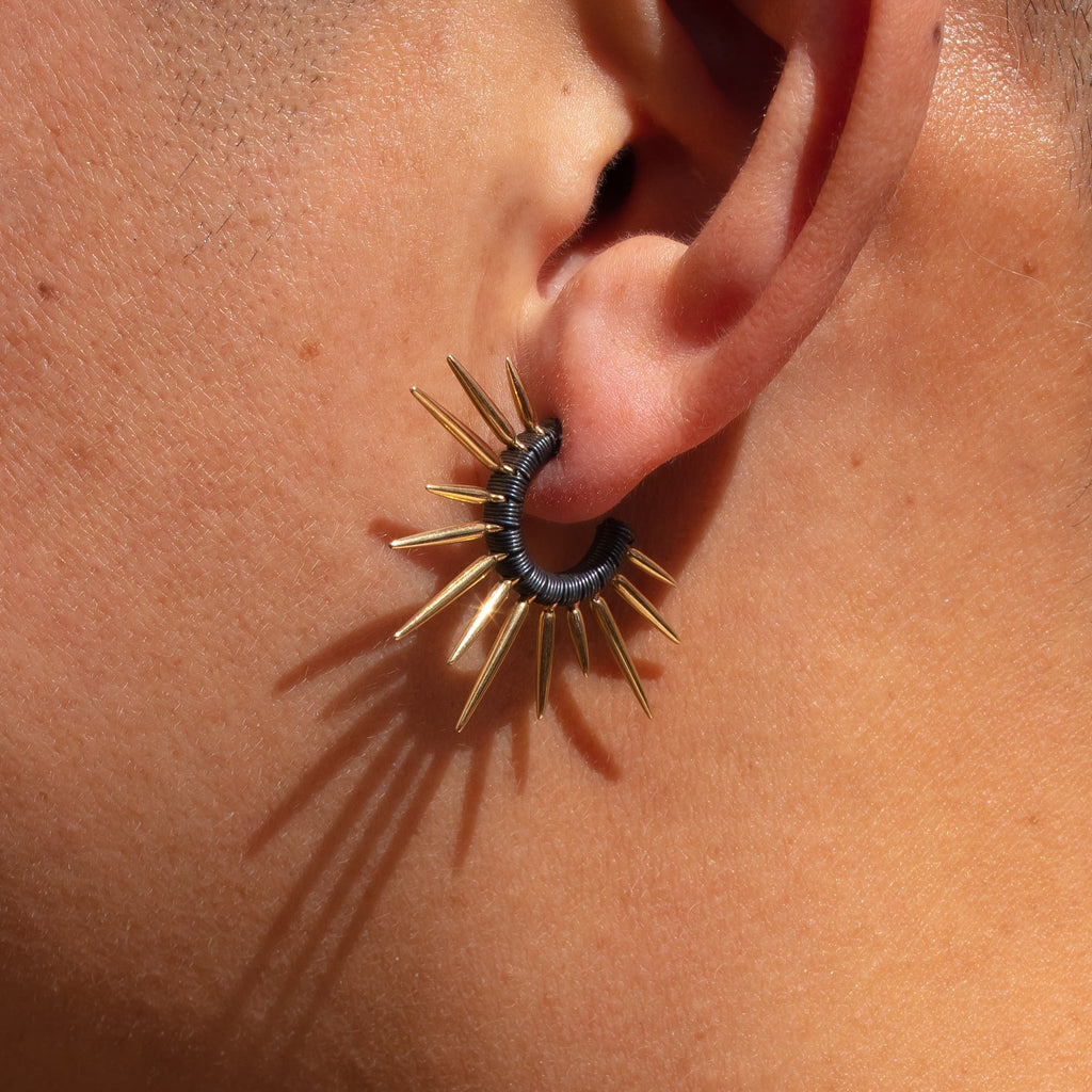 14k gold and oxidized silver spiky urchin earrings on model 