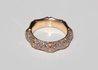 Gold bamboo ring with pave set diamonds on a light gray background