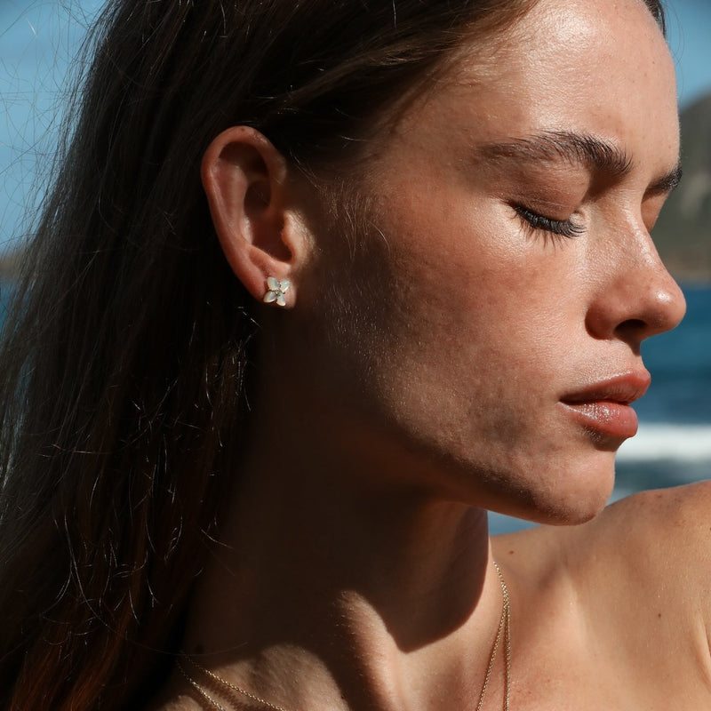 gold mother of pearl flower earrings with diamonds on model