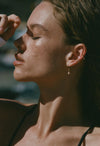 simple gold hoop earrings with lavender pearl charm on model