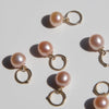 14k gold peach pearl charms on a light background