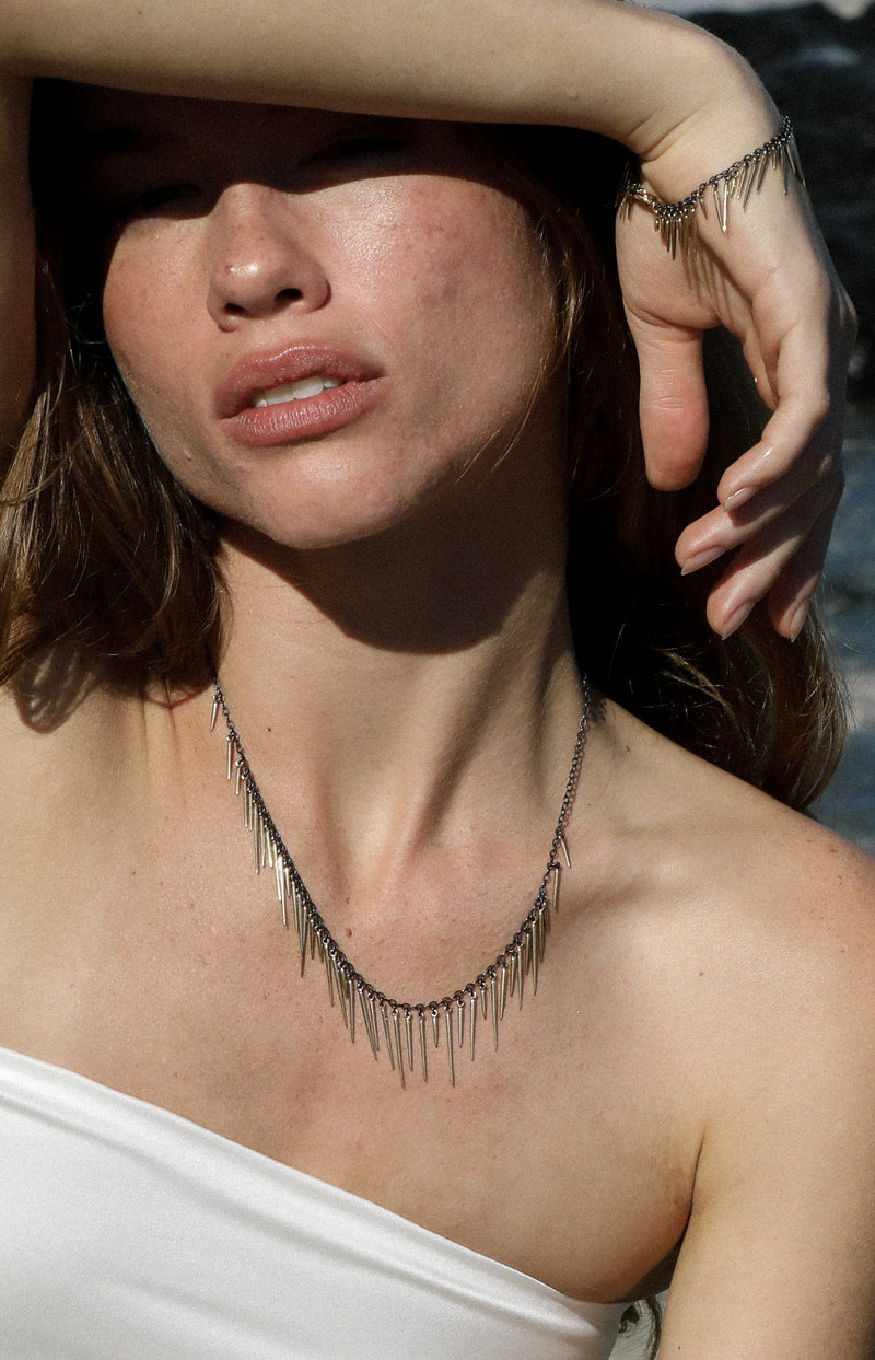 fringe necklace and bracelet with gold urchin spines and black chain on model