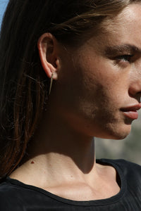 gold urchin spine earrings with diamond on model