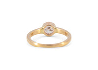 back of gold ring with a diamond on a white background