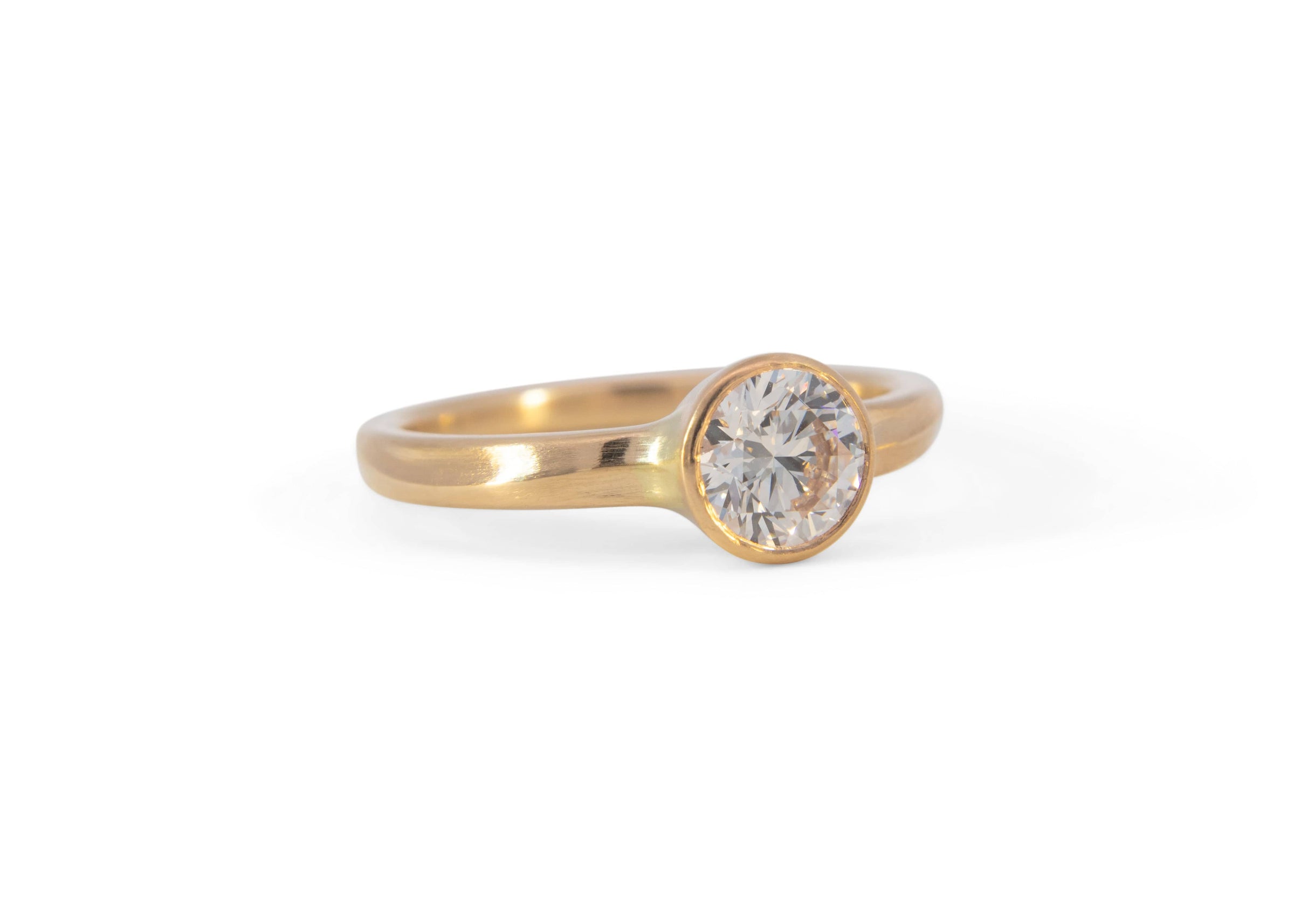 gold wave engagement ring with diamond on white background