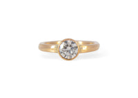 Gold wave ring with a diamond on a white background