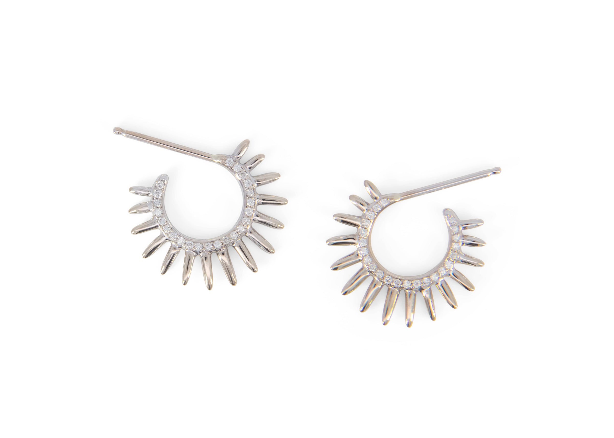 Pair of spiky silver hoop earrings with diamonds on a white background