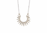Silver sun-shaped necklace with small stones on a white background