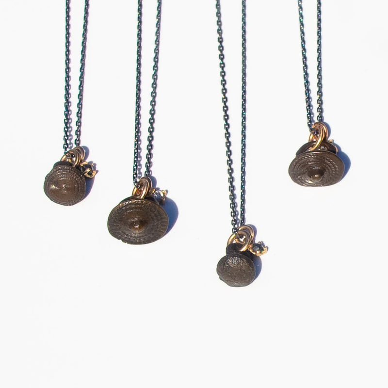 oxidized silver and gold necklace with rose cut salt and pepper diamond and bronze viking button