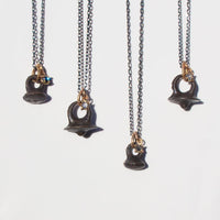 oxidized silver and gold necklace with rose cut salt and pepper diamond and bronze viking button