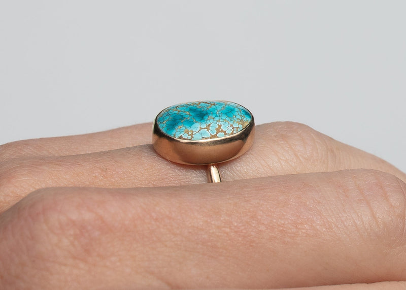 side view of 14k gold bezel set iron maiden turquoise ring on hand