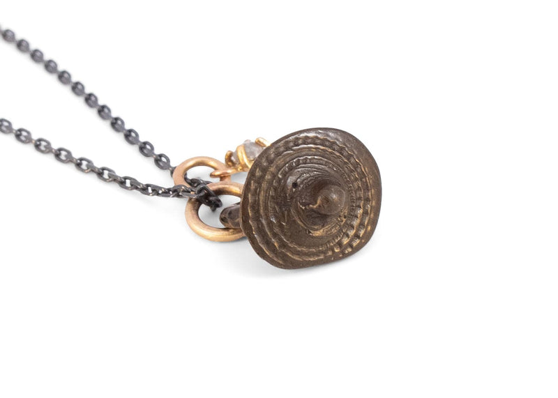 oxidized silver and gold necklace with rose cut salt and pepper diamond and bronze viking button