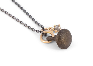 oxidized silver and gold necklace with rose cut salt and pepper diamond and bronze viking button