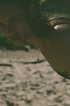 green moonstone necklace on model in front of ocean