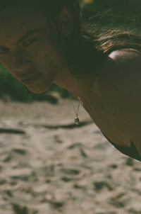 green moonstone necklace on model in front of ocean