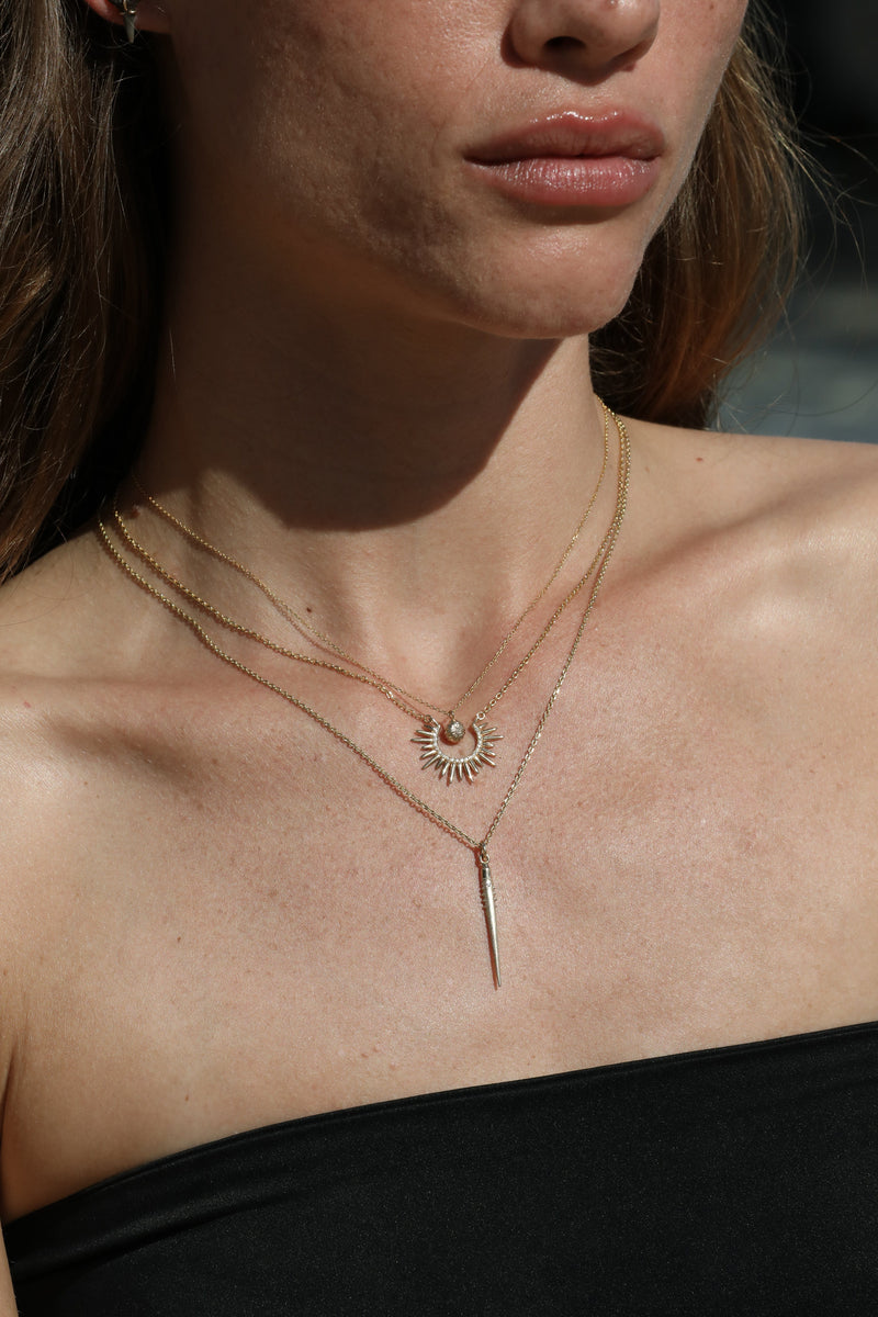 spiky gold necklaces with diamonds on model