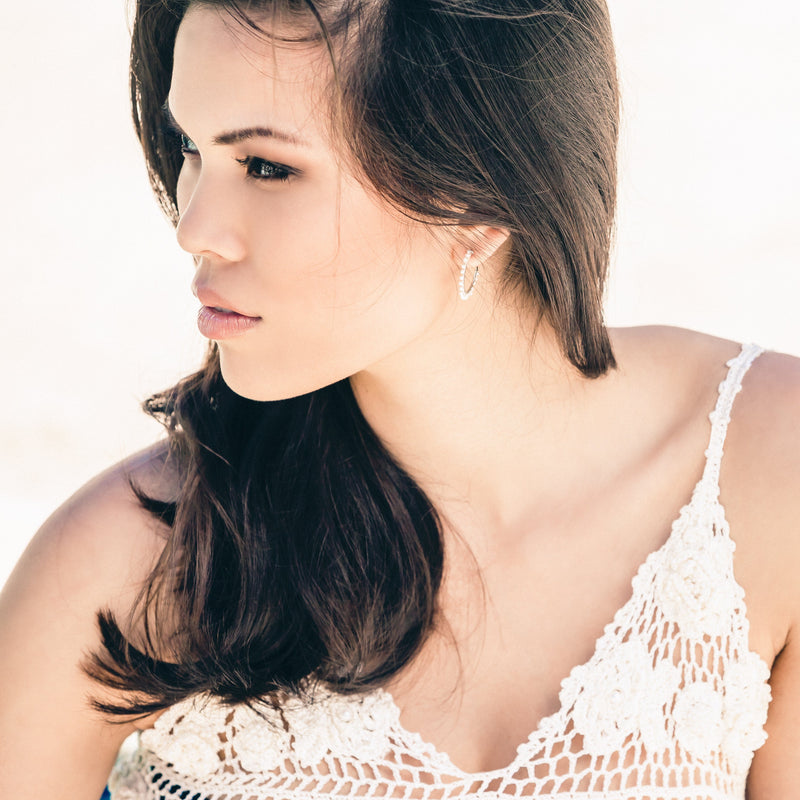 model wearing white pearl hoop earrings