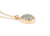 side of 14k gold green moonstone necklace with scalloped bezel