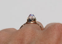 antique inspired ring with bullet shaped blue moonstone in scalloped setting on hand