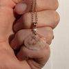 solid 14k gold pink and white shell necklace with rose cut diamond in hand