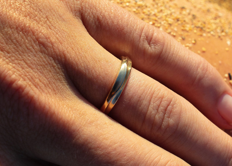 14k gold women's undulating wave wedding band on hand