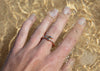 gold rockweed seaweed ring on hand in water
