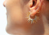 model wearing spiky 14k gold earrings with pave set diamonds