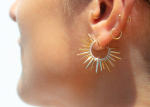model wearing spiky 14k gold earrings with pave set diamonds