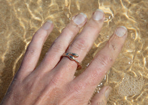 gold seaweed ring on hand in water