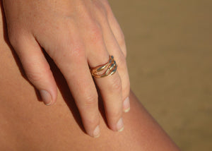 14k gold rockweed rings on hand at beach