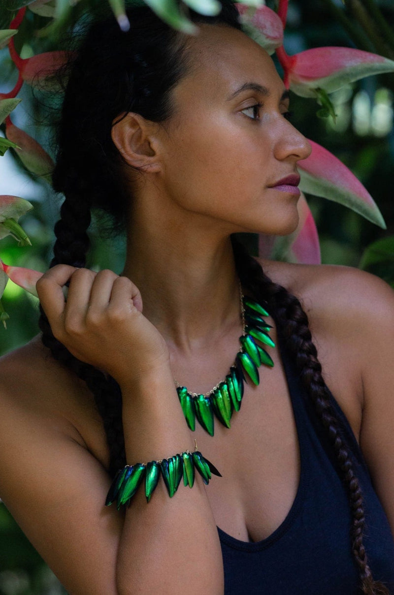 green scarab beetle wing jewelry on model in jungle