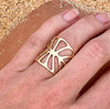 14k gold cutout leaf ring on hand in sand