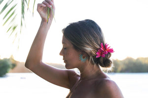 model with pink flowers in hair wearing spiky blue sea urchin inspired earrings
