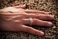 sterling silver rockweed seaweed ring on hand in sand