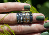 urchin shell inspired rings with inverted gemstones on hand with green nail polish