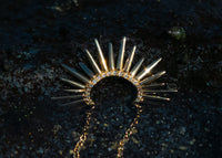 spiky gold necklace with pave set diamonds in tidepool in lava rock