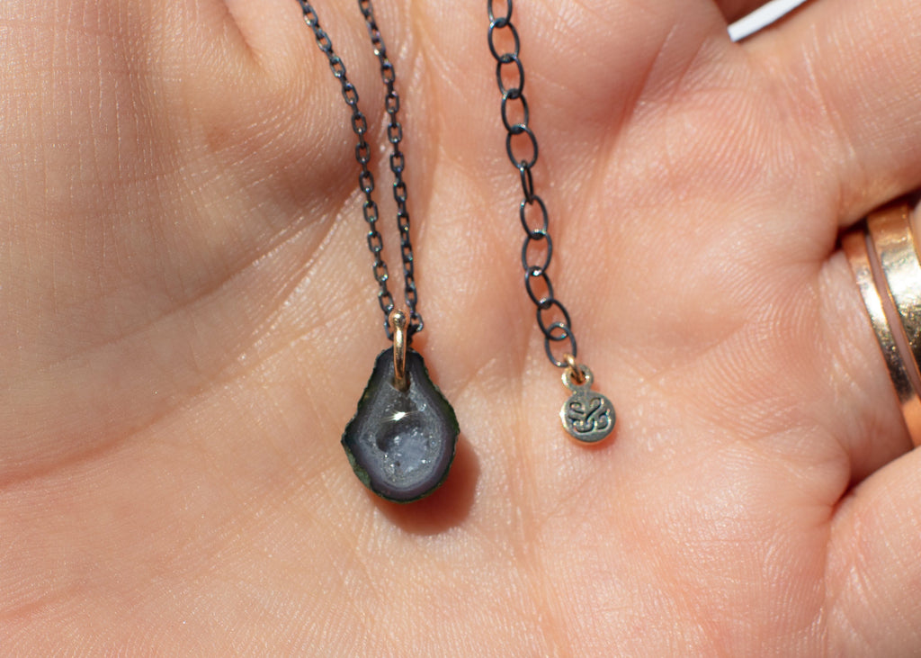 gray pear shaped tabasco geode necklace in hand
